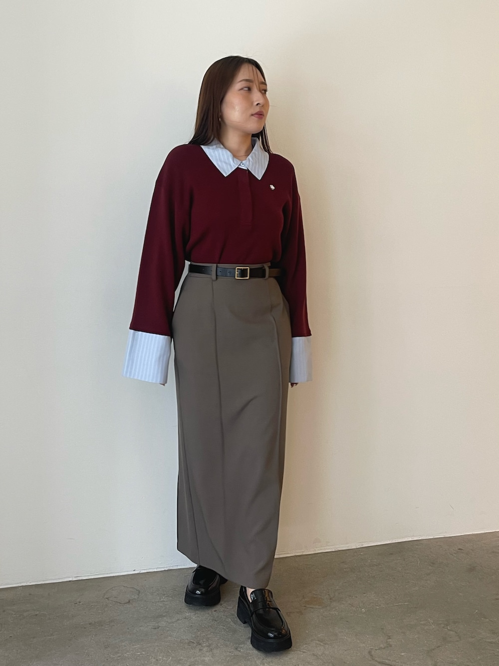 グレー系のスカート、レッド系のニット/セーターを着用したレディースの夏コーディネートの3枚目の写真