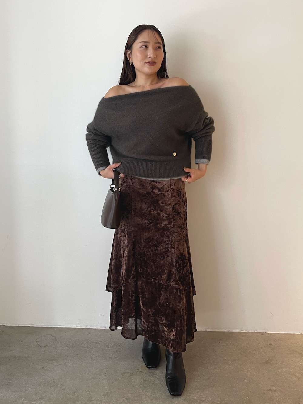 ブラウン系のハンドバッグ、ブラウン系のニット/セーター、ブラウン系のスカートを着用したレディースの秋コーディネートの4枚目の写真