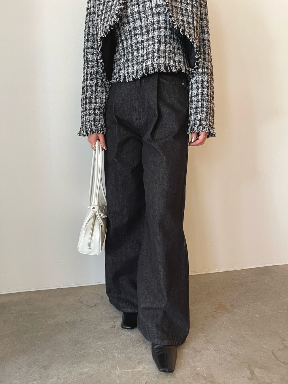 ホワイト系のショルダーバッグ、ブラック系のキャミソール、ブラック系のテーラードジャケットを着用したレディースの秋コーディネートの8枚目の写真