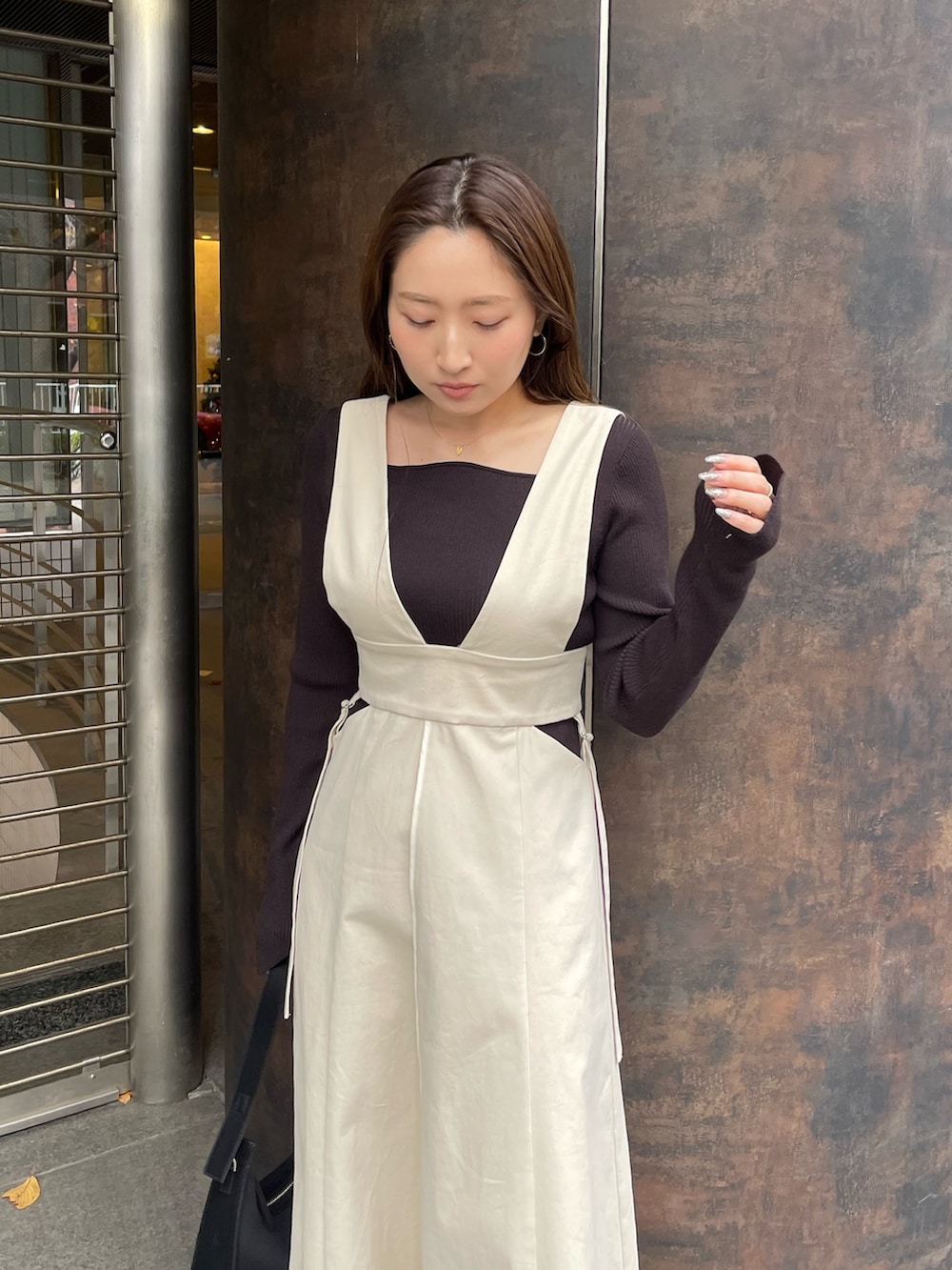 ホワイト系のブーツ、ホワイト系のジャンパースカート、ブラック系のニット/セーターを着用したレディースの冬コーディネートの9枚目の写真