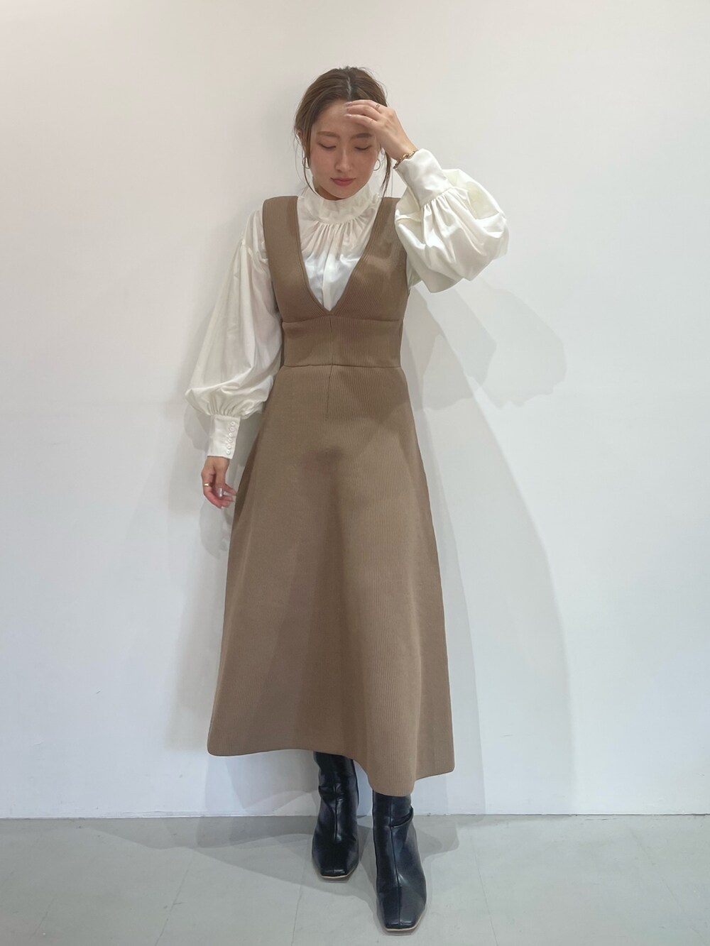 ベージュ系のジャンパースカート、ホワイト系のシャツ/ブラウス、ブラック系のブーツを着用したレディースの秋コーディネートの4枚目の写真