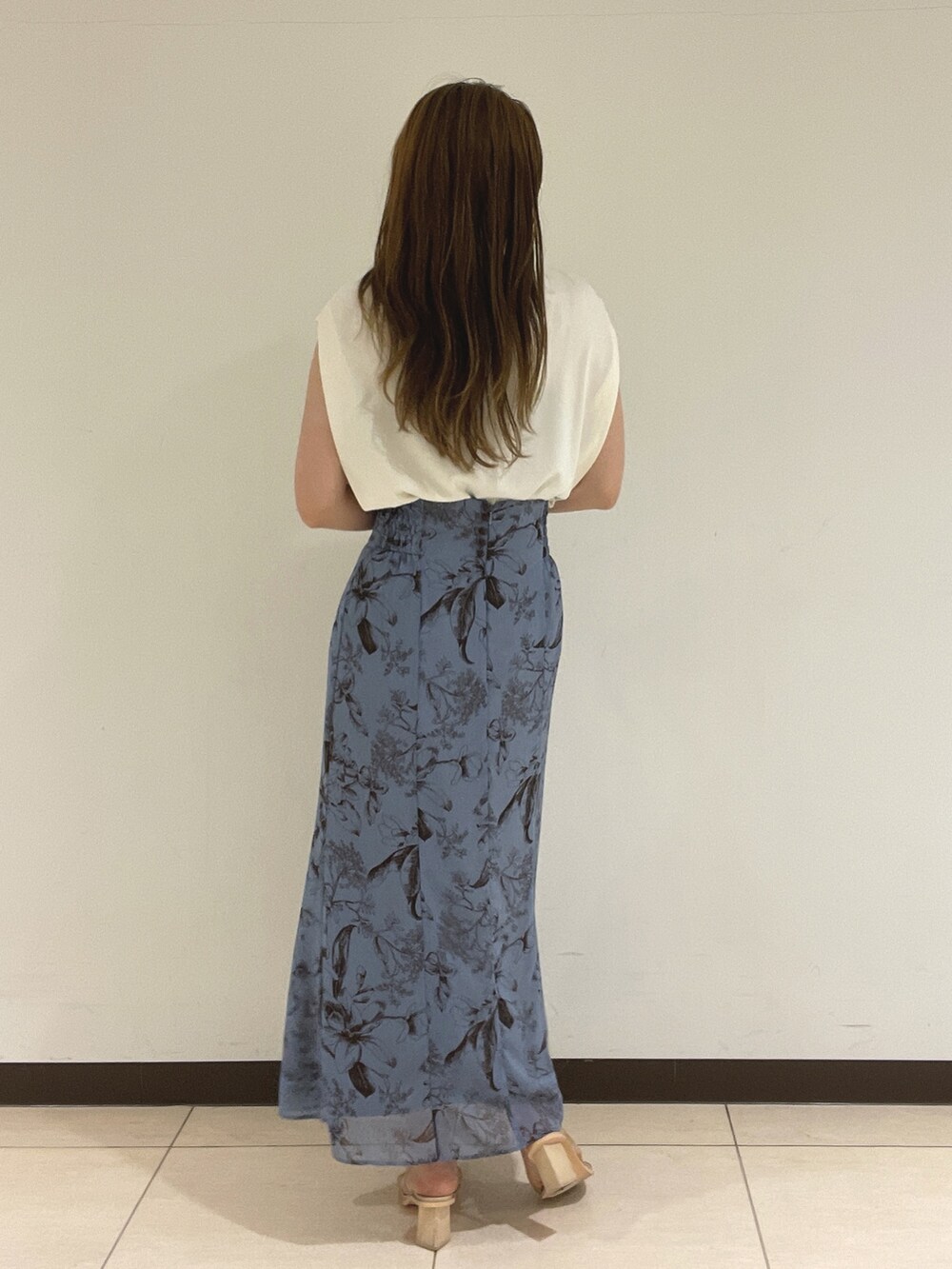 ブルー系のスカート、ホワイト系のニット/セーターを着用したレディースの夏コーディネートの7枚目の写真