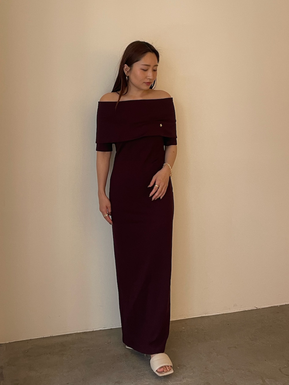 ブラウン系のワンピース、ホワイト系のサンダル、ゴールド系のブレスレットを着用したレディースの春コーディネートの2枚目の写真