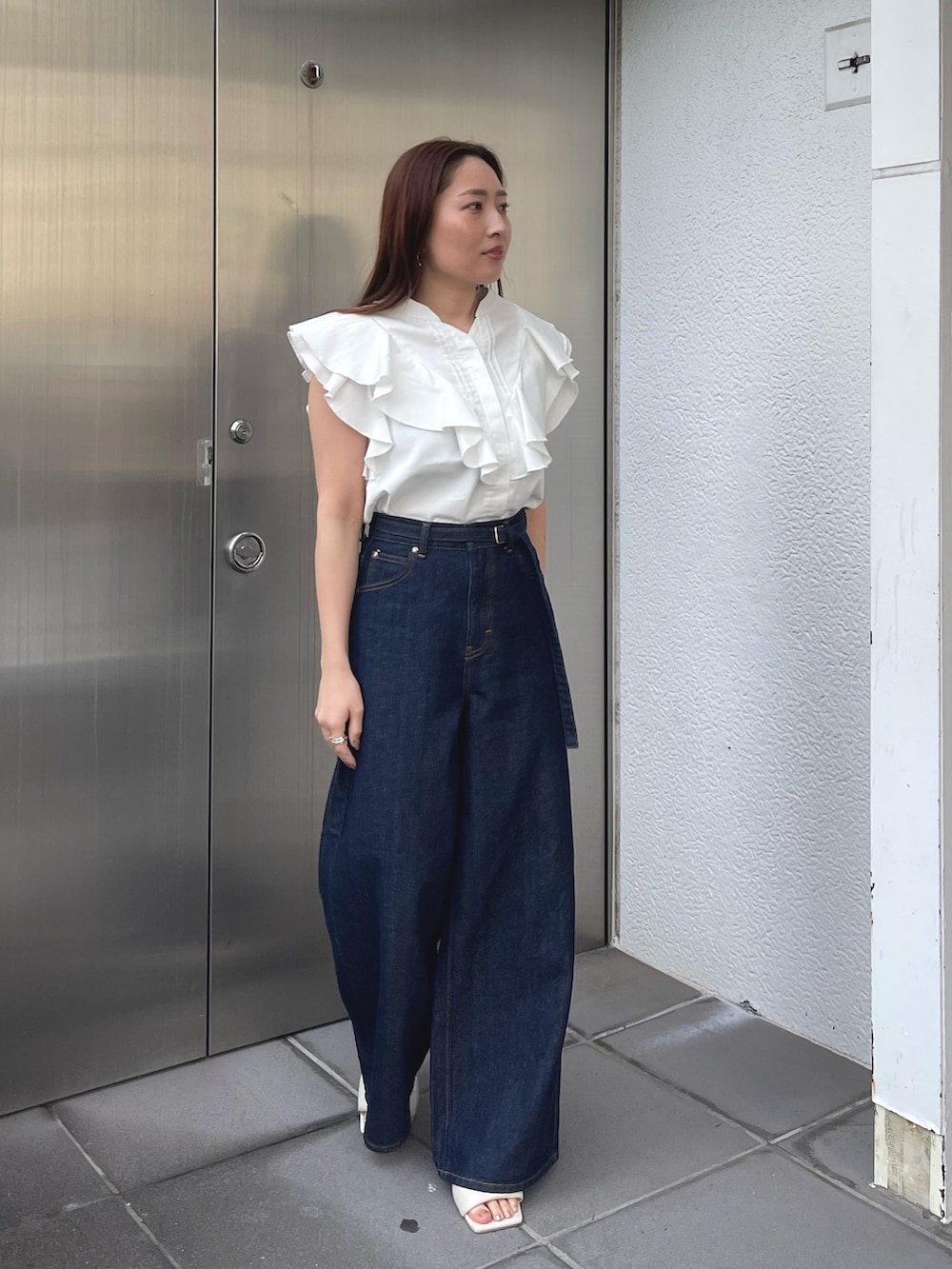 ホワイト系のサンダル、ホワイト系のシャツ/ブラウス、ブルー系のデニムパンツを着用したレディースの春コーディネートの5枚目の写真