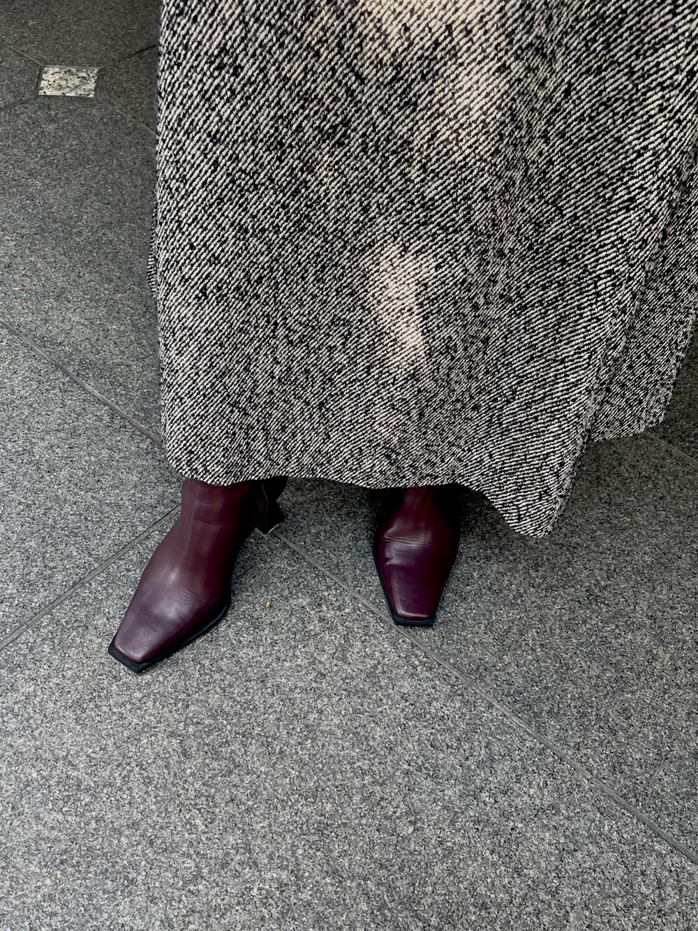 ブラック系のスカート、レッド系のブーツを着用したレディースの秋コーディネートの7枚目の写真