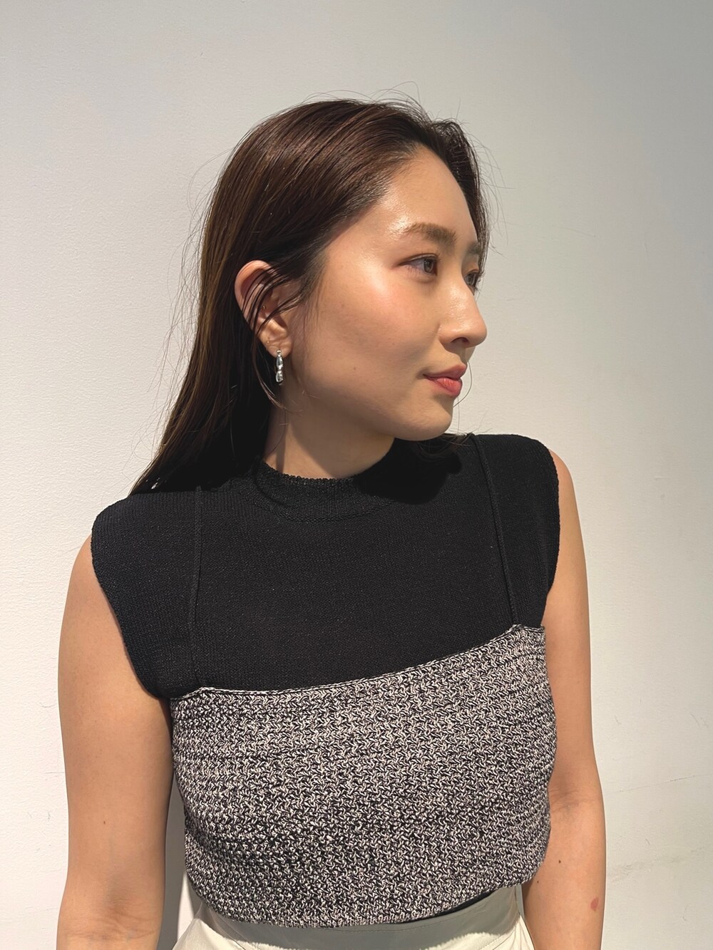 シルバー系のパンプス、ブラック系のニット/セーター、ホワイト系のスカートを着用したレディースの春コーディネートの7枚目の写真