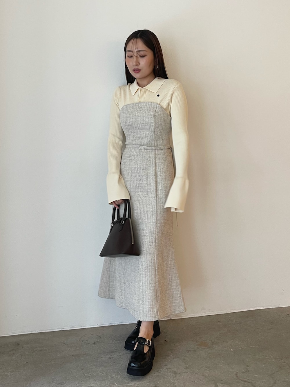 ブラウン系のボストンバッグ、ホワイト系のワンピース、ブラック系のローファーを着用したレディースの夏コーディネートの3枚目の写真