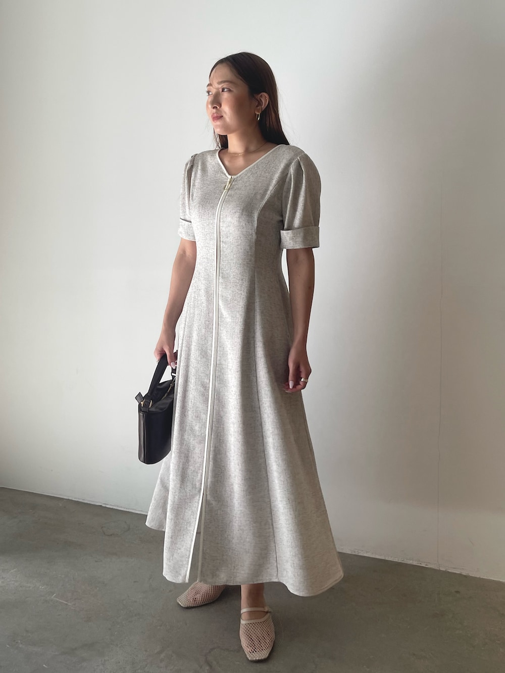 ブラウン系のハンドバッグ、ホワイト系のワンピースを着用したレディースの冬コーディネートの6枚目の写真