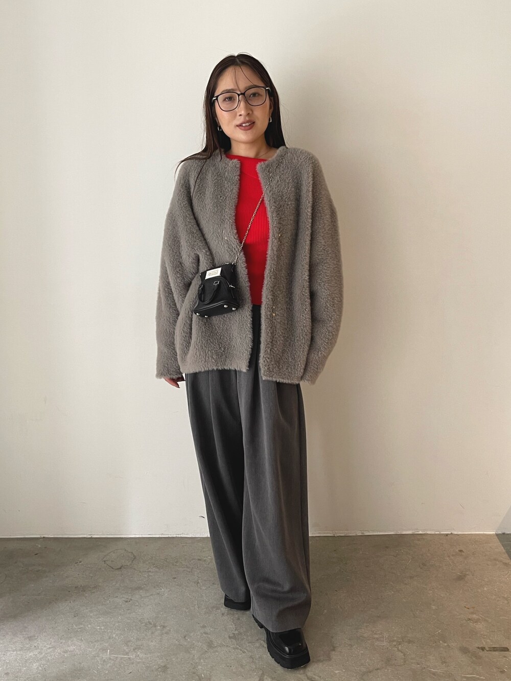 ブラック系のローファー、グレー系のその他パンツ、レッド系のニット/セーターを着用したレディースの秋コーディネートの6枚目の写真
