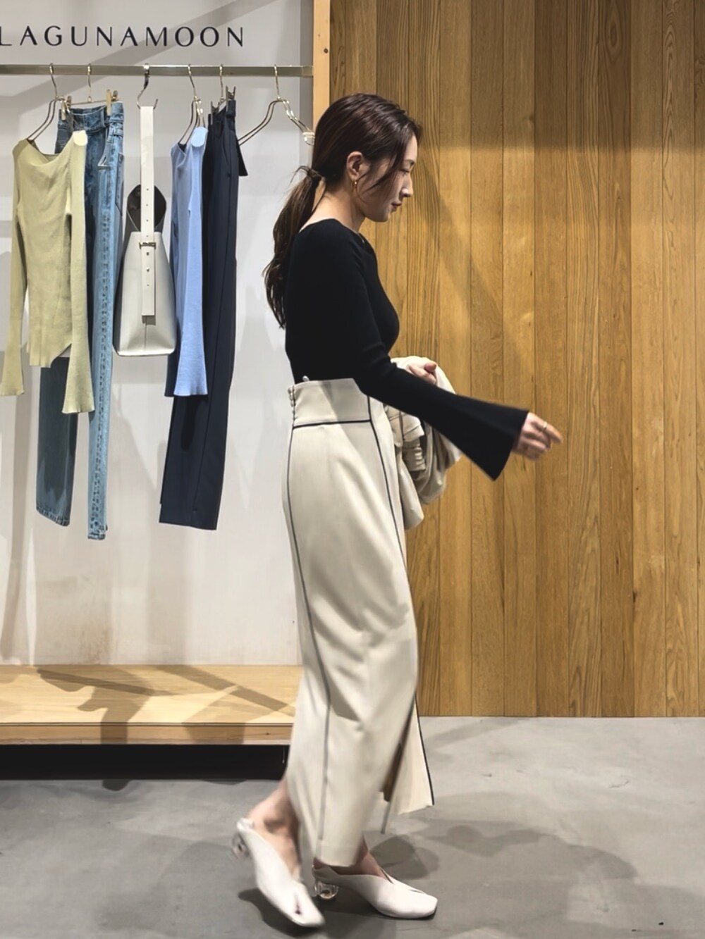 ベージュ系のスカート、ホワイト系のパンプス、ブラック系のニット/セーターを着用したレディースの冬コーディネートの6枚目の写真