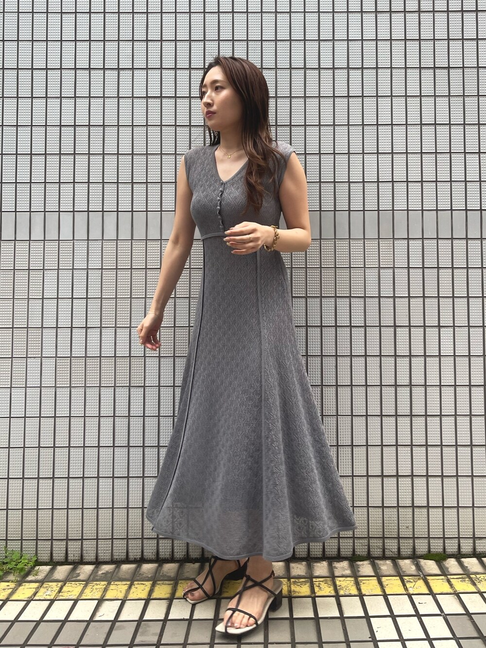 グレー系のワンピース、ブラック系のサンダル、グレー系のカーディガン/ボレロを着用したレディースの春コーディネートの9枚目の写真