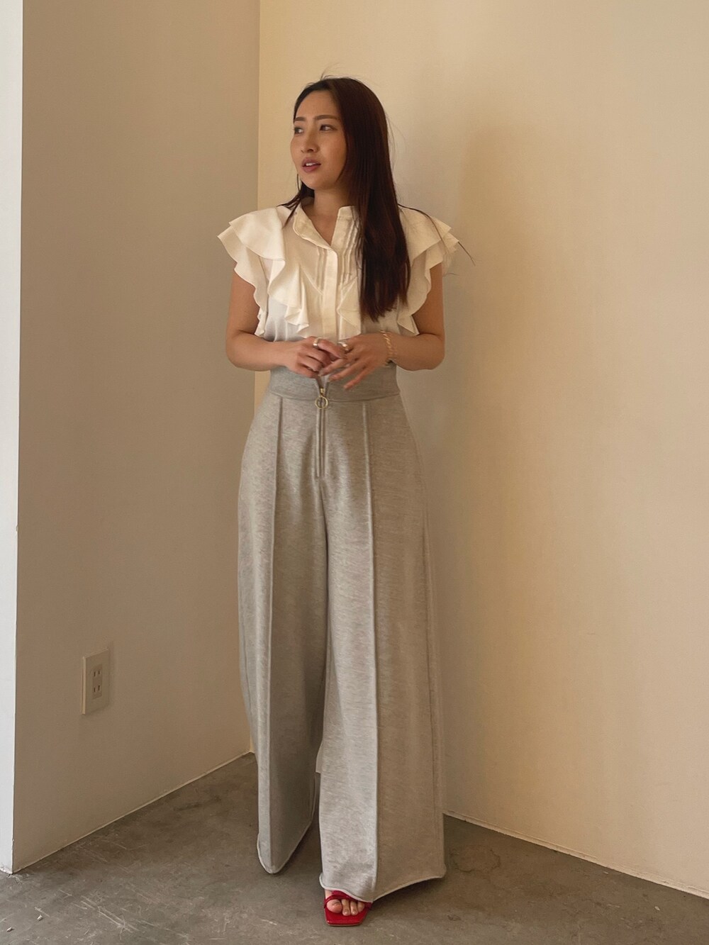 レッド系のサンダル、ホワイト系のシャツ/ブラウス、グレー系のスウェットパンツを着用したレディースの春コーディネートの2枚目の写真