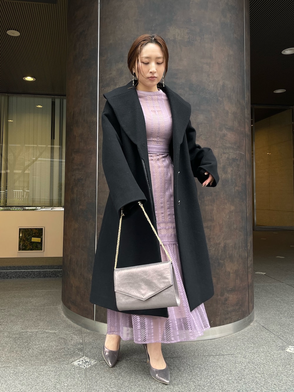 シルバー系のパンプス、シルバー系のハンドバッグ、ブラック系のその他アウターを着用したレディースの冬コーディネートの3枚目の写真