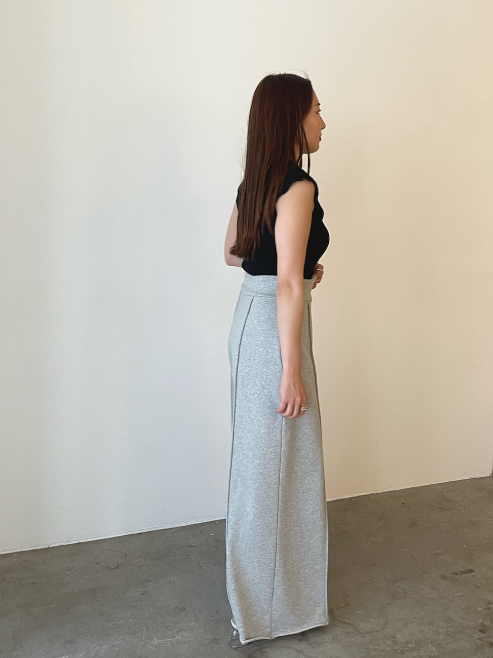 グレー系のスウェットパンツ、ホワイト系のサンダル、ブラック系のニット/セーターを着用したレディースの春コーディネートの4枚目の写真