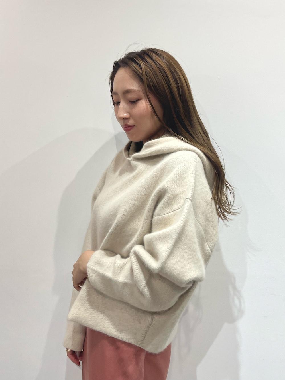 ピンク系のスカート、ベージュ系のブーツ、ホワイト系のパーカーを着用したレディースの夏コーディネートの6枚目の写真