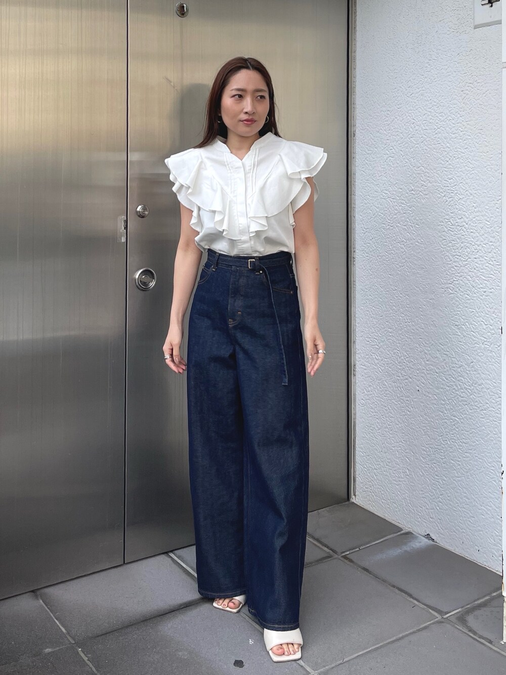 ホワイト系のサンダル、ホワイト系のシャツ/ブラウス、ブルー系のデニムパンツを着用したレディースの春コーディネートの3枚目の写真