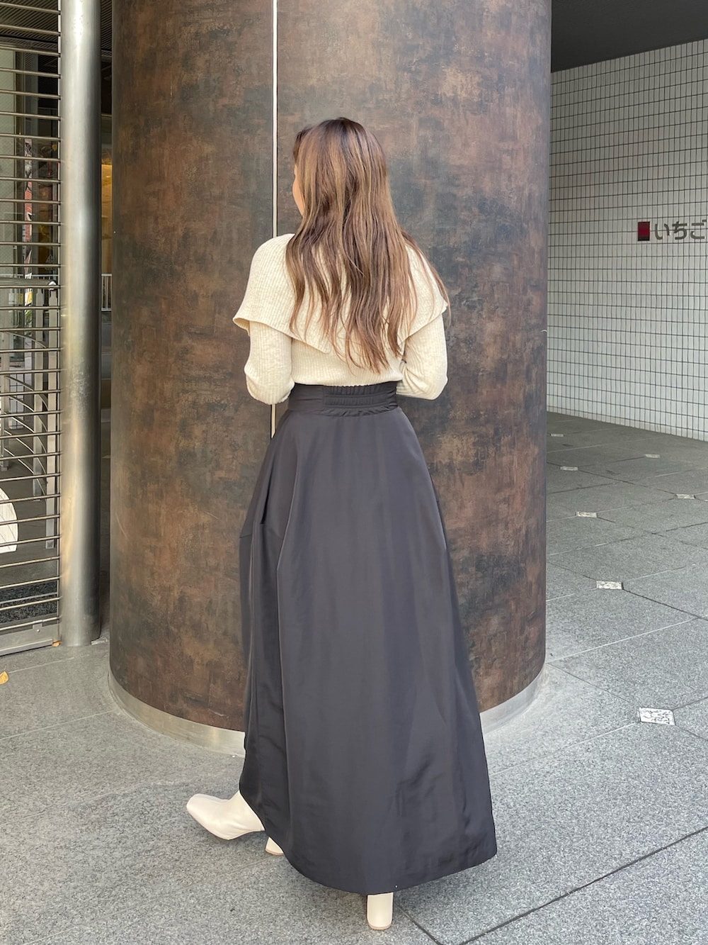 ホワイト系のブーツ、ベージュ系のニット/セーター、ブラック系のスカートを着用したレディースの冬コーディネートの4枚目の写真