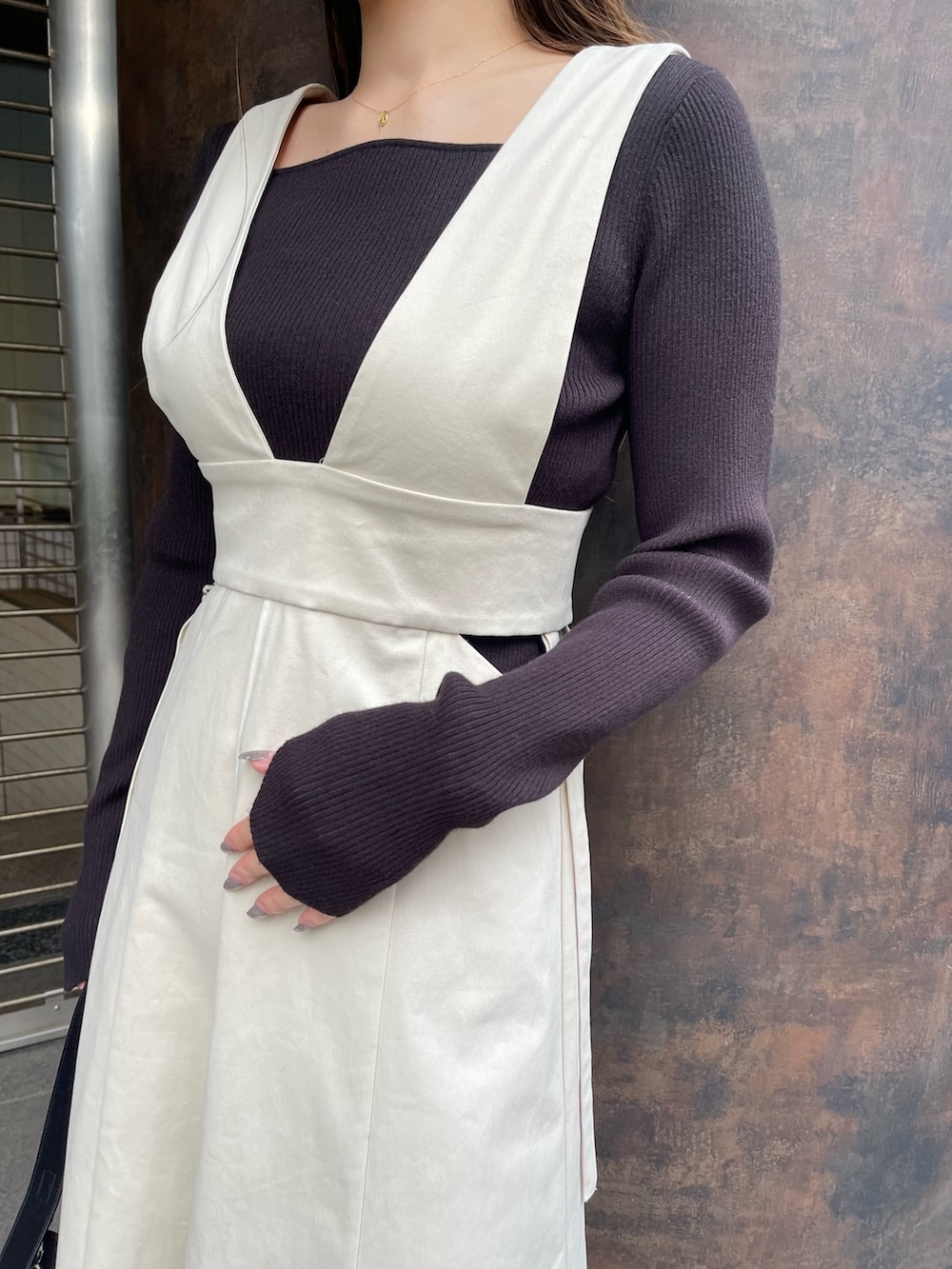 ホワイト系のブーツ、ホワイト系のジャンパースカート、ブラック系のニット/セーターを着用したレディースの冬コーディネートの8枚目の写真