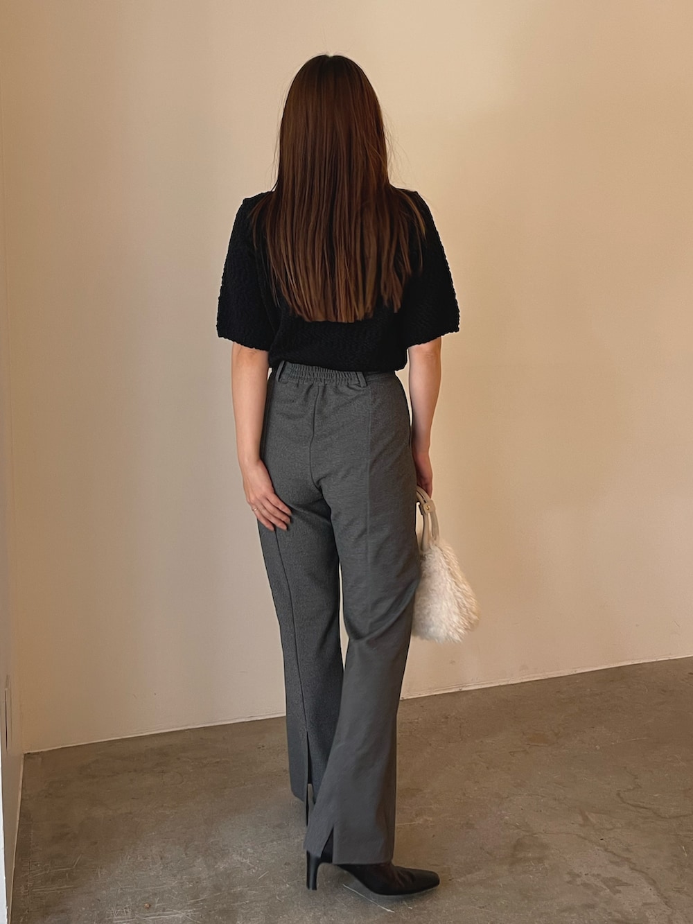 ホワイト系のボストンバッグ、ブラック系のブーツ、ブラック系のニット/セーターを着用したレディースの夏コーディネートの7枚目の写真