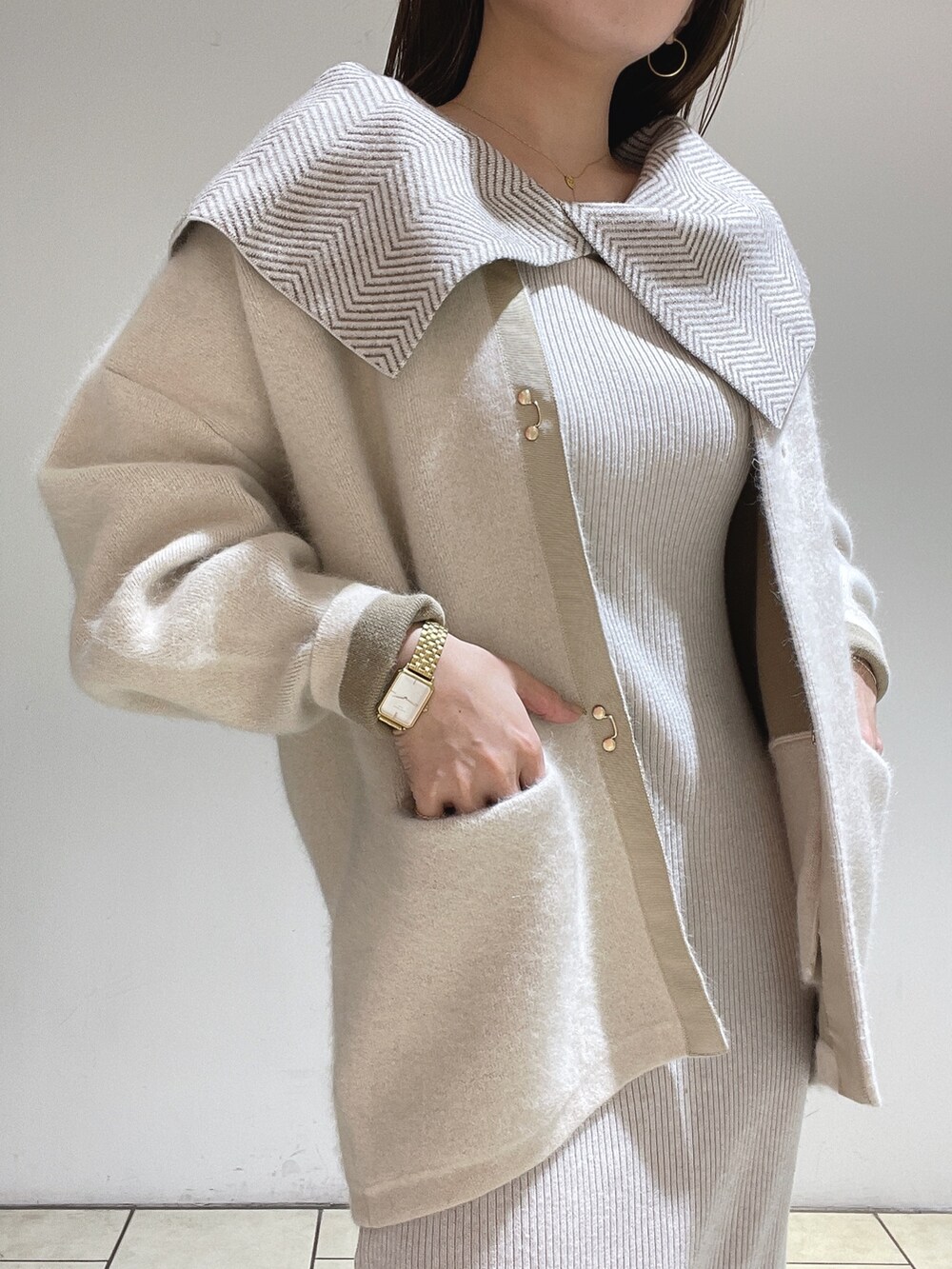 ホワイト系のワンピース、ホワイト系のカーディガン/ボレロ、ベージュ系のブーツを着用したレディースの冬コーディネートの9枚目の写真