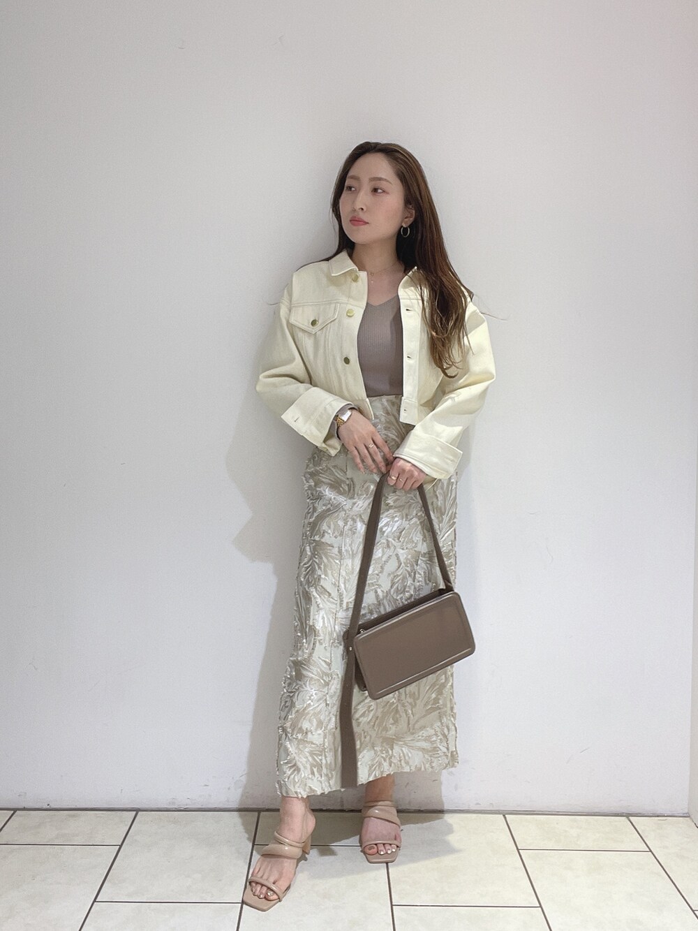 ベージュ系のスカート、ベージュ系のサンダル、ブラウン系のショルダーバッグを着用したレディースの春コーディネートの5枚目の写真