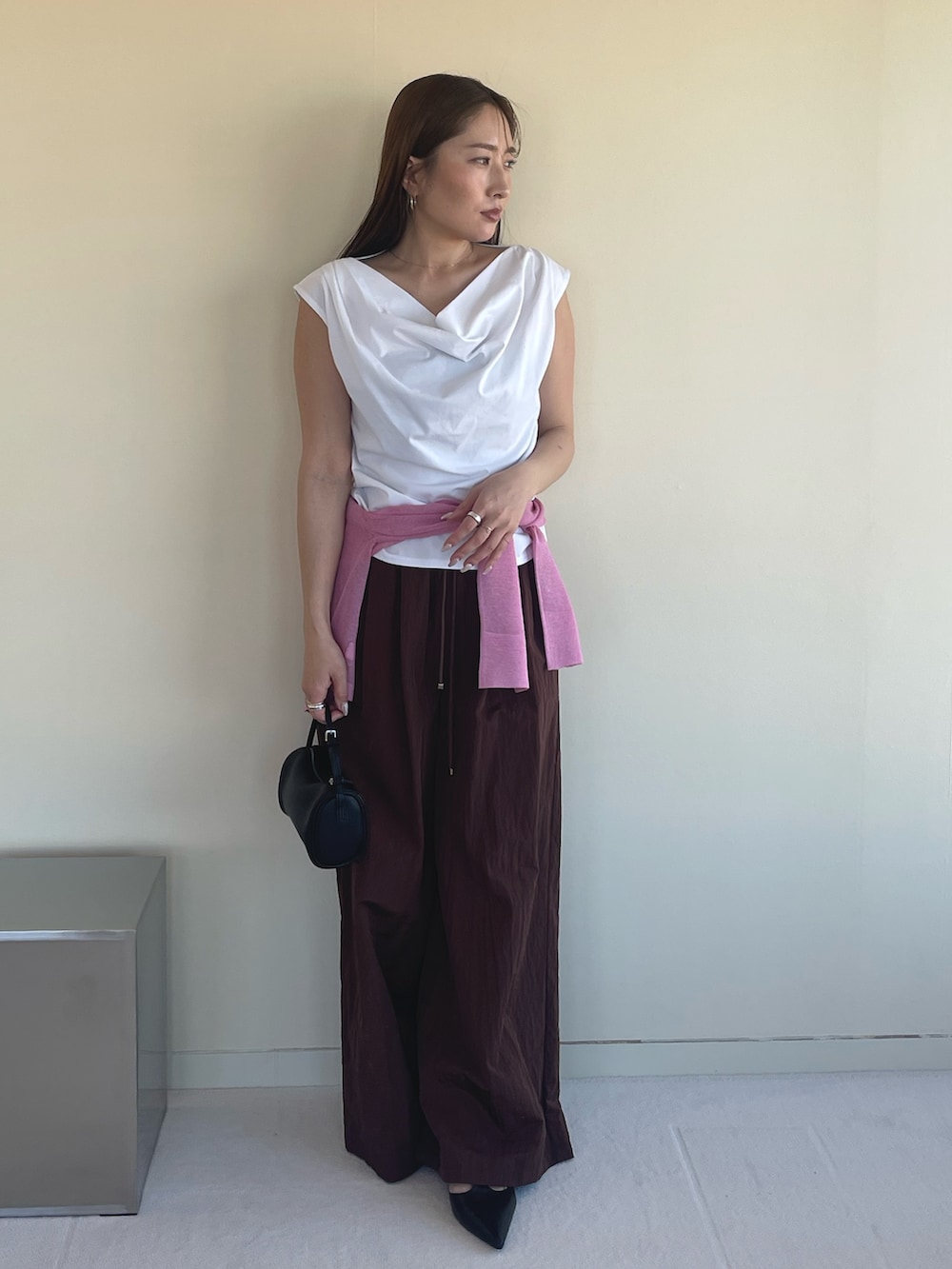 ホワイト系のTシャツ/カットソー、ピンク系のカーディガン/ボレロ、ブラック系のパンプスを着用したレディースの春コーディネートの2枚目の写真