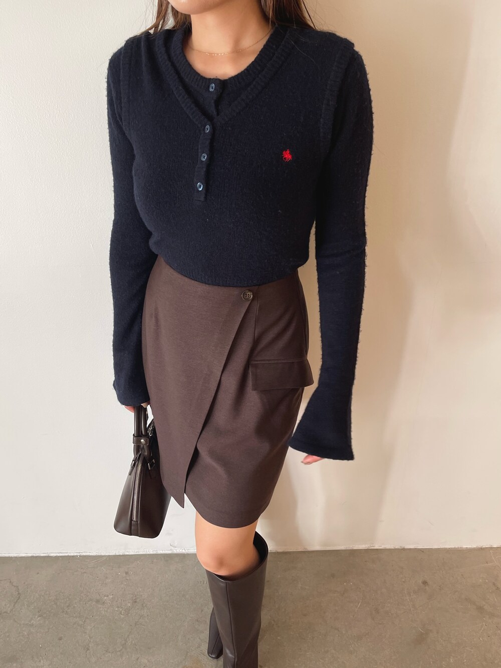 ブラウン系のボストンバッグ、ブラウン系のスカート、ブルー系のニット/セーターを着用したレディースの夏コーディネートの8枚目の写真