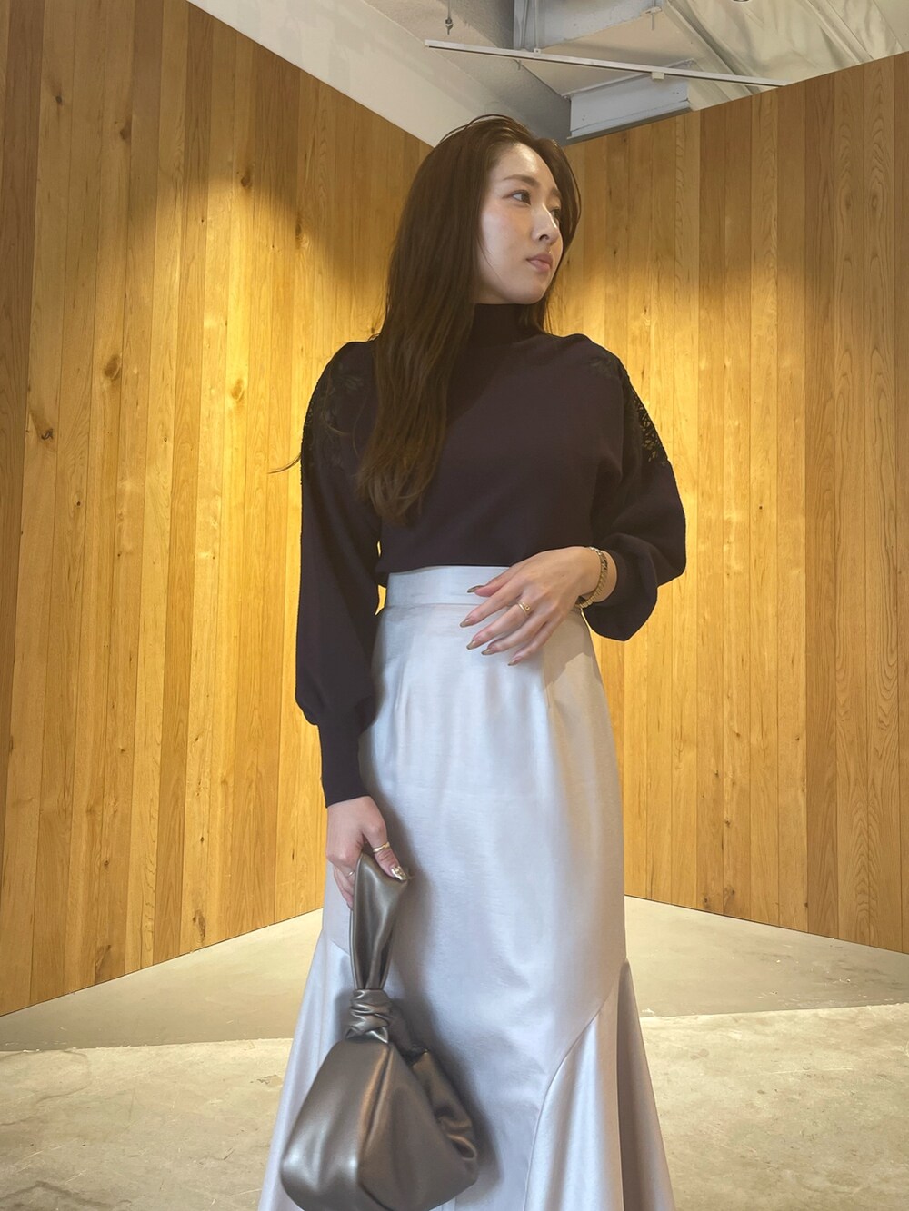 グレー系のニット/セーター、その他のハンドバッグ、ブラウン系のスカートを着用したレディースの秋コーディネートの6枚目の写真