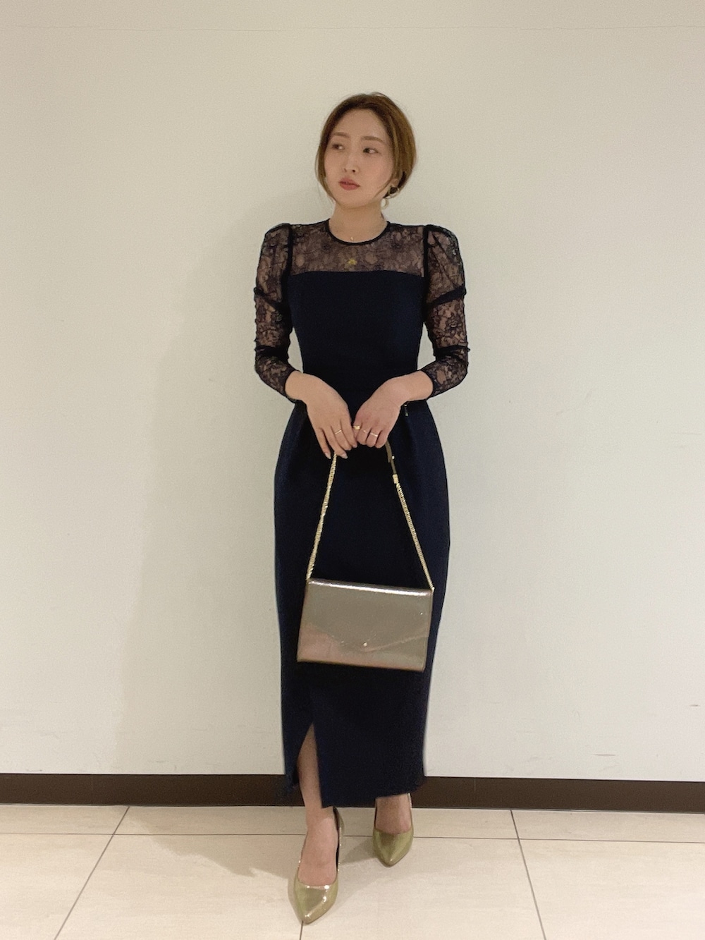 ゴールド系のハンドバッグ、ゴールド系のパンプス、ブルー系のドレスを着用したレディースの夏コーディネートの8枚目の写真