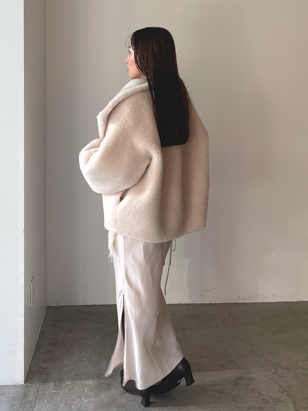 ベージュ系のワンピース、ブラウン系のハンドバッグ、ブラウン系のブーツを着用したレディースの冬コーディネートの5枚目の写真