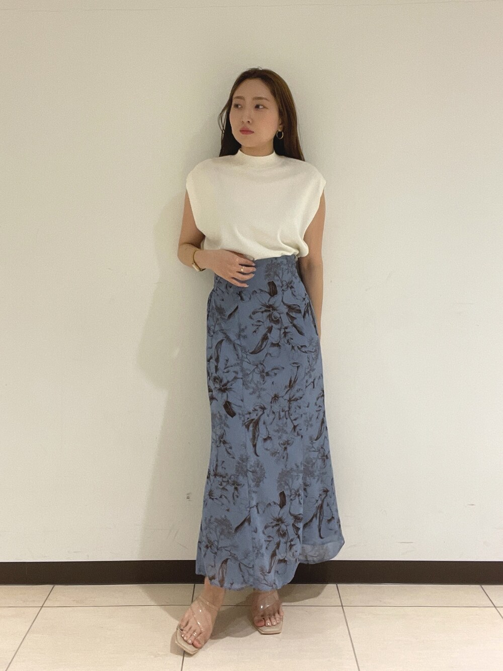 ブルー系のスカート、ホワイト系のニット/セーターを着用したレディースの夏コーディネートの5枚目の写真