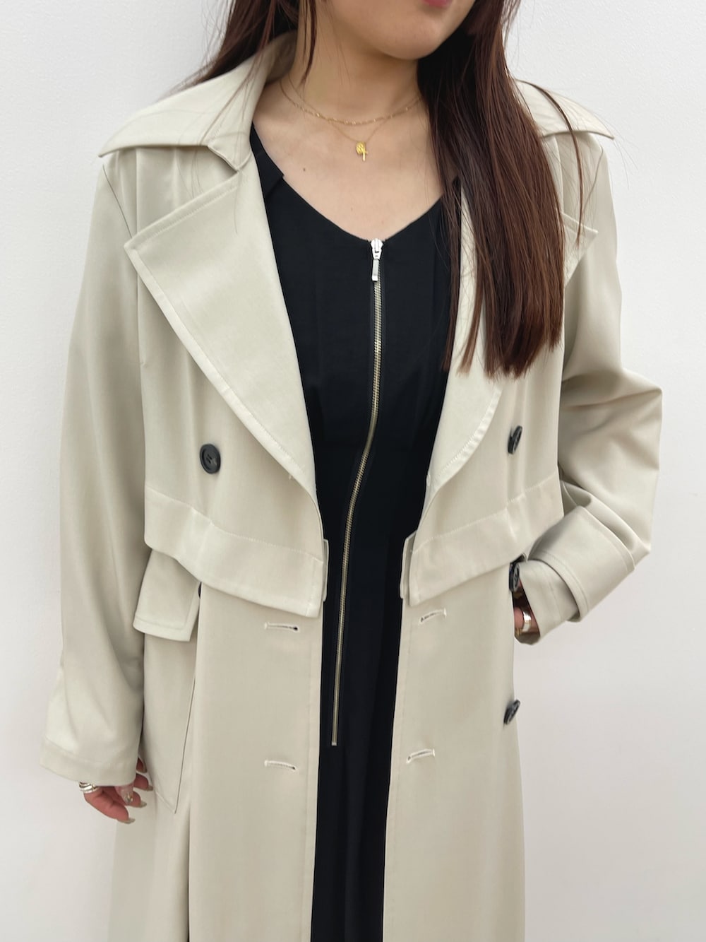 ホワイト系のトレンチコート、ブラック系のワンピース、ホワイト系のサンダルを着用したレディースの春コーディネートの7枚目の写真