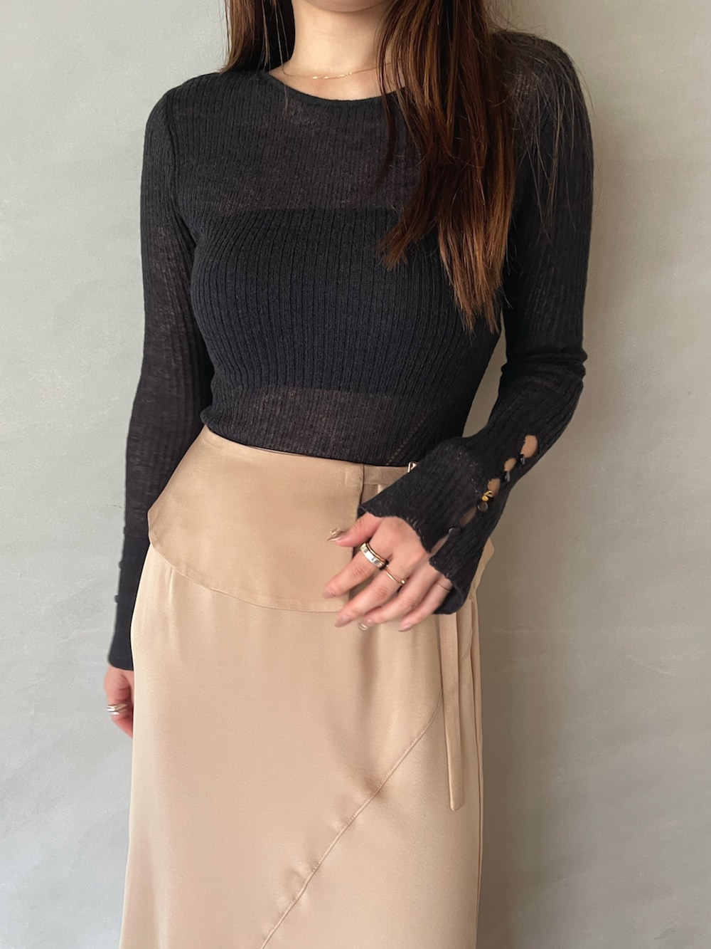 ベージュ系のスカート、ブラック系のニット/セーターを着用したレディースの夏コーディネートの7枚目の写真