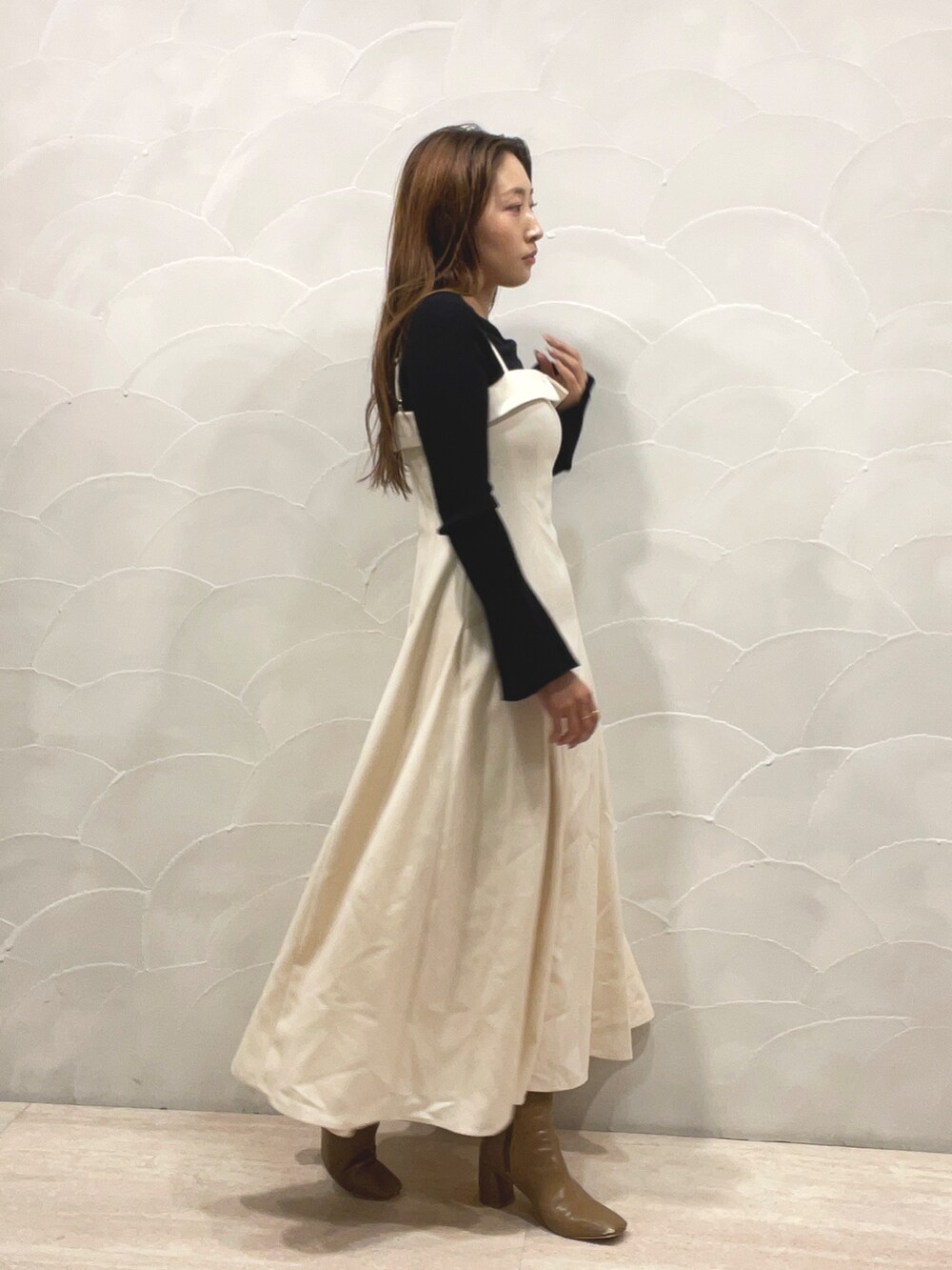 ベージュ系のブーツ、ブラック系のニット/セーター、ホワイト系のワンピースを着用したレディースの秋コーディネートの5枚目の写真