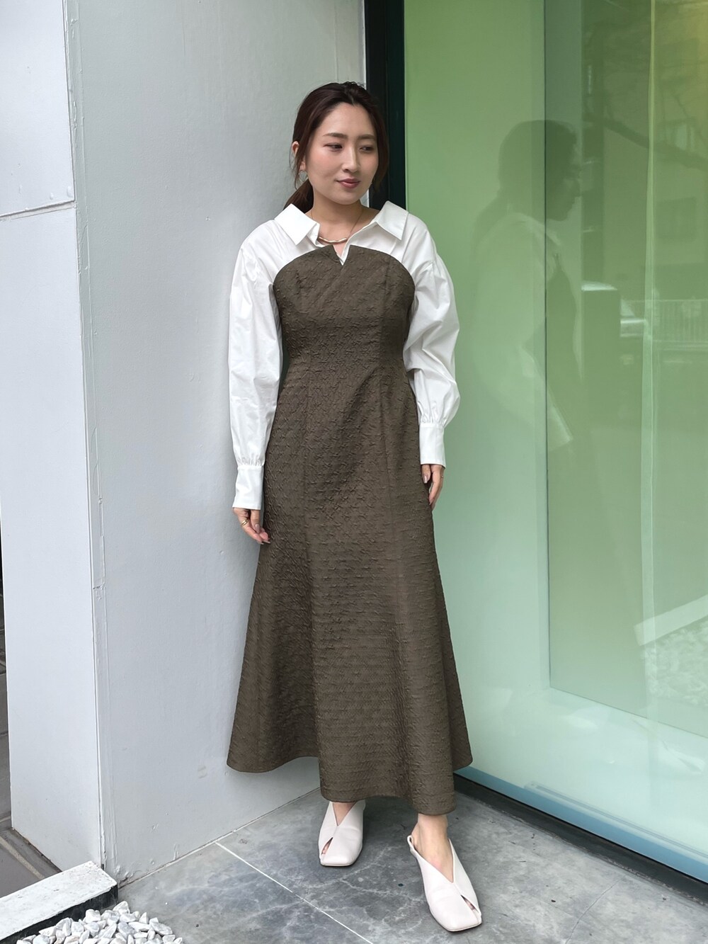 ホワイト系のパンプス、ブラウン系のワンピース、ゴールド系のネックレスを着用したレディースの春コーディネートの3枚目の写真