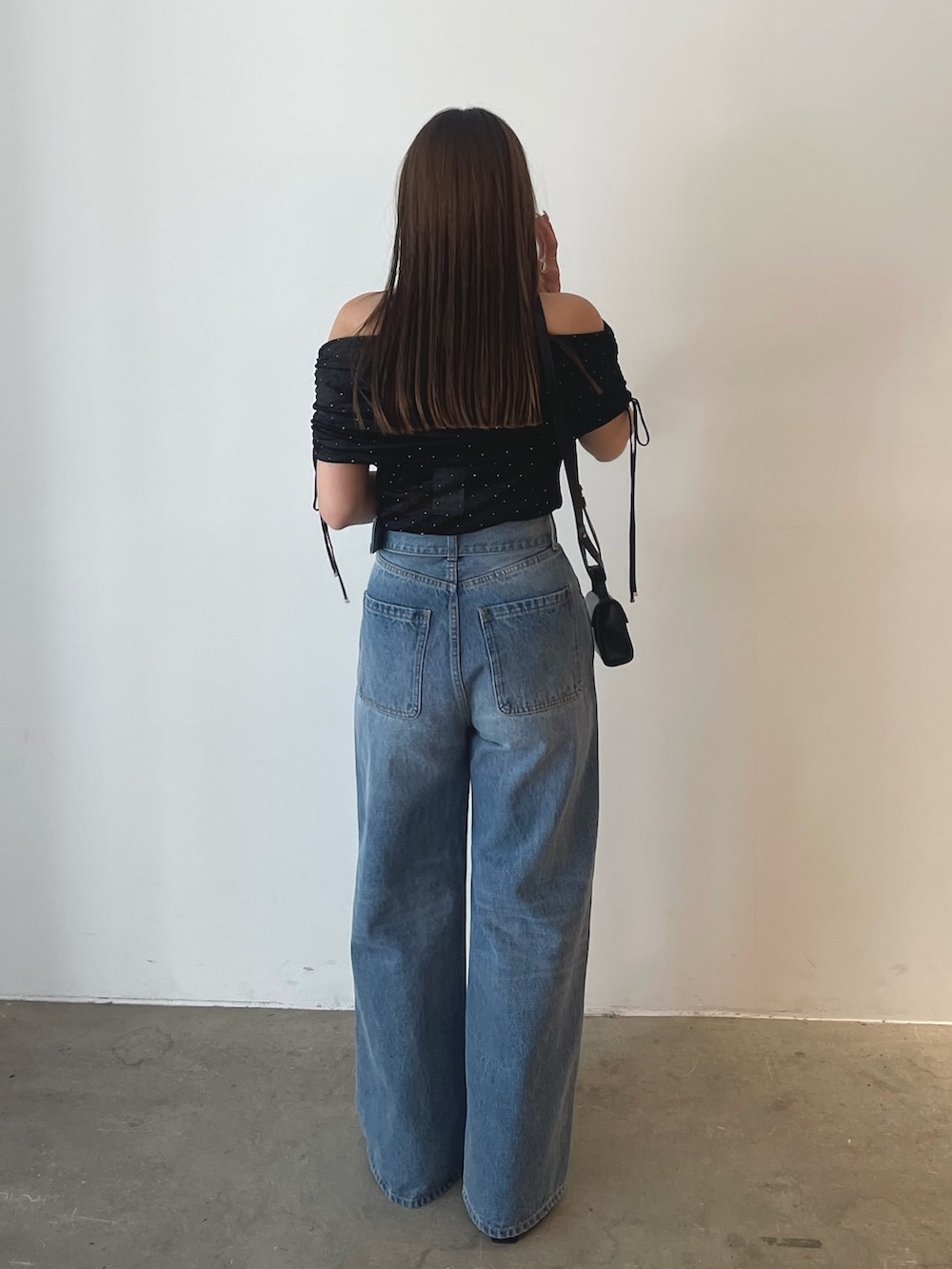 ブラック系のTシャツ/カットソー、ブルー系のデニムパンツを着用したレディースの夏コーディネートの6枚目の写真