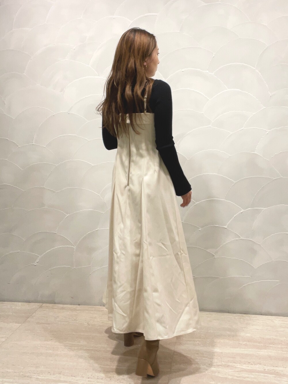 ベージュ系のブーツ、ブラック系のニット/セーター、ホワイト系のワンピースを着用したレディースの秋コーディネートの4枚目の写真