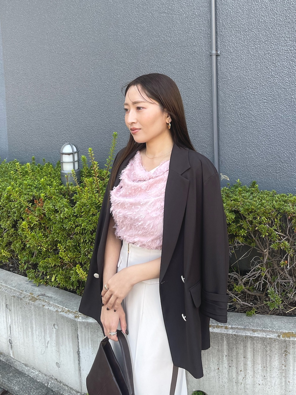 ブラウン系のハンドバッグ、ピンク系のシャツ/ブラウス、ブラック系のパンプスを着用したレディースの冬コーディネートの8枚目の写真