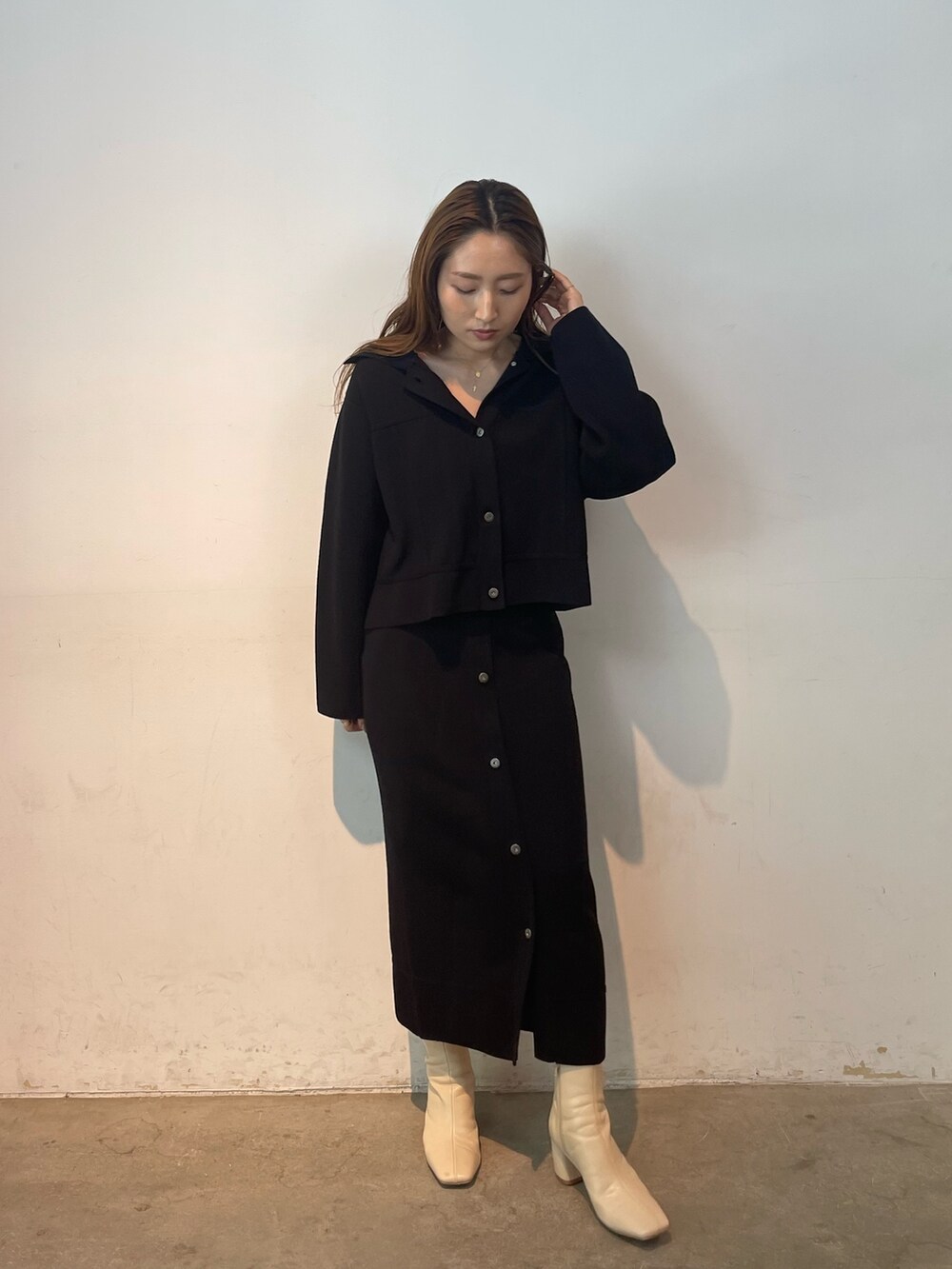 ブラック系のカーディガン/ボレロ、ブラック系のスカート、ホワイト系のブーツを着用したレディースの夏コーディネートの3枚目の写真