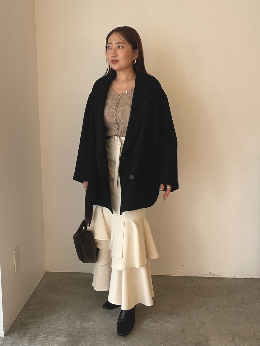 ベージュ系のワンピース、ブラック系のブーツ、ブラウン系のショルダーバッグを着用したレディースの冬コーディネートの3枚目の写真