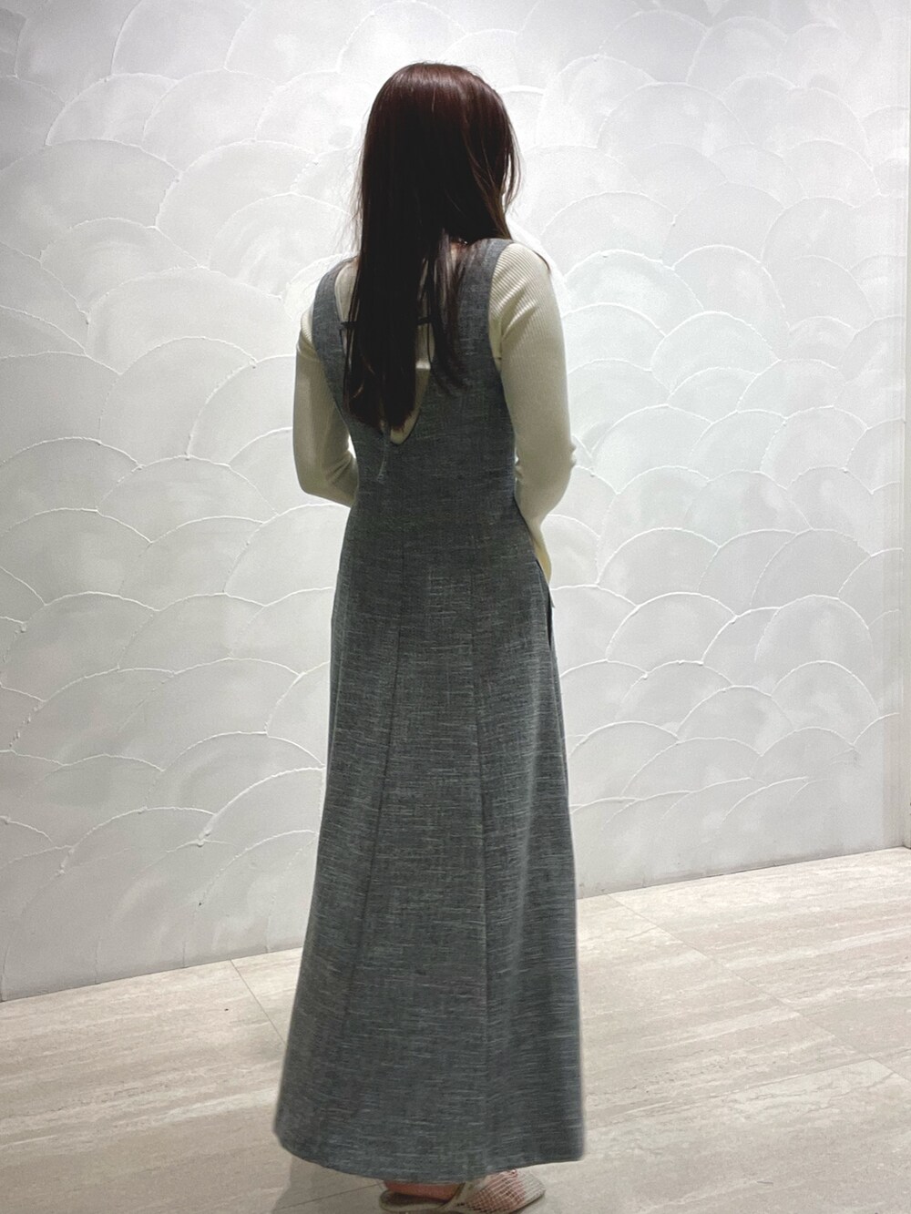 ホワイト系のサンダル、ホワイト系のニット/セーター、グレー系のジャンパースカートを着用したレディースの春コーディネートの5枚目の写真