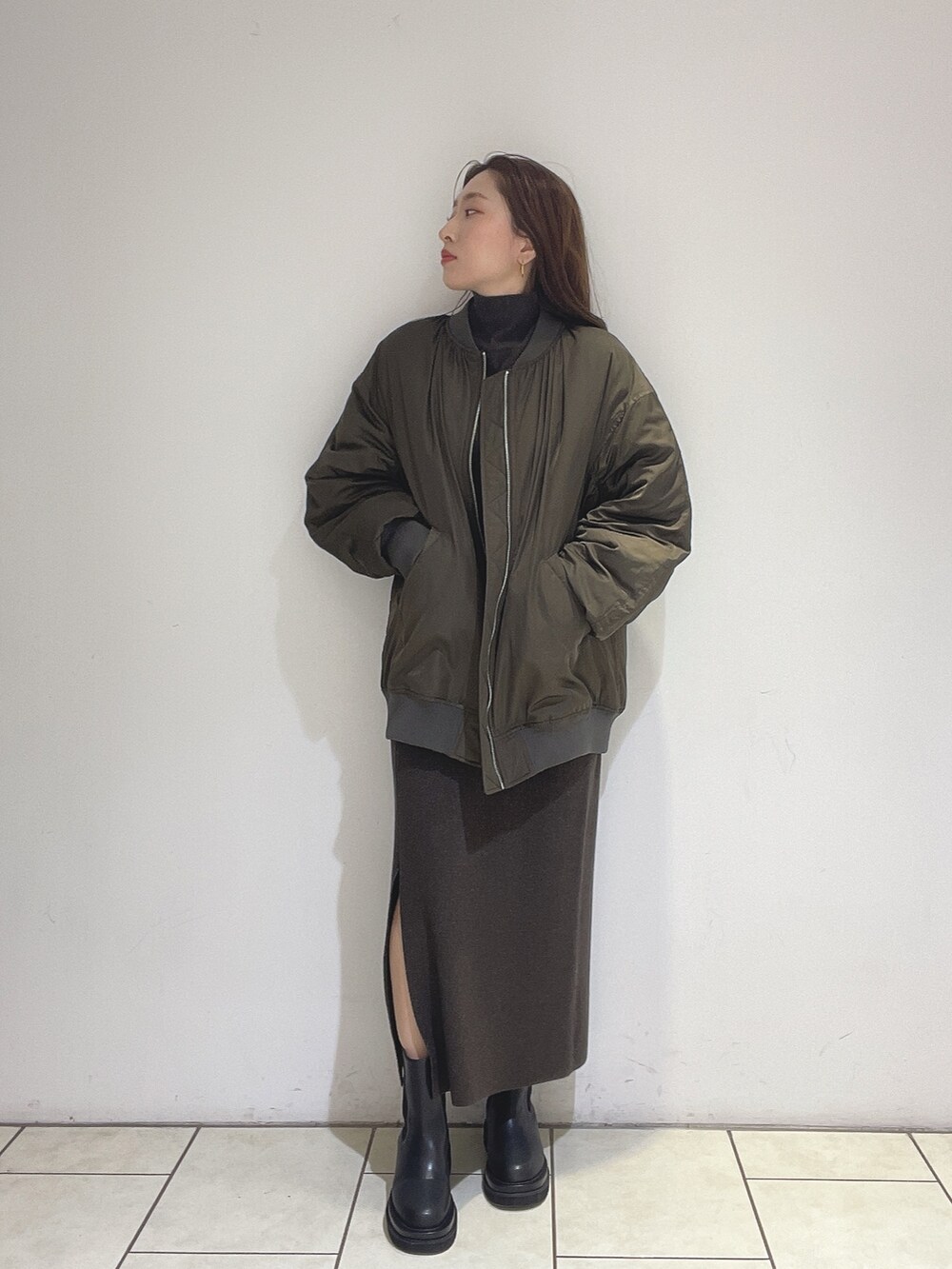 ブラウン系のニット/セーター、ブラウン系のスカート、ブラック系のブーツを着用したレディースの冬コーディネートの4枚目の写真