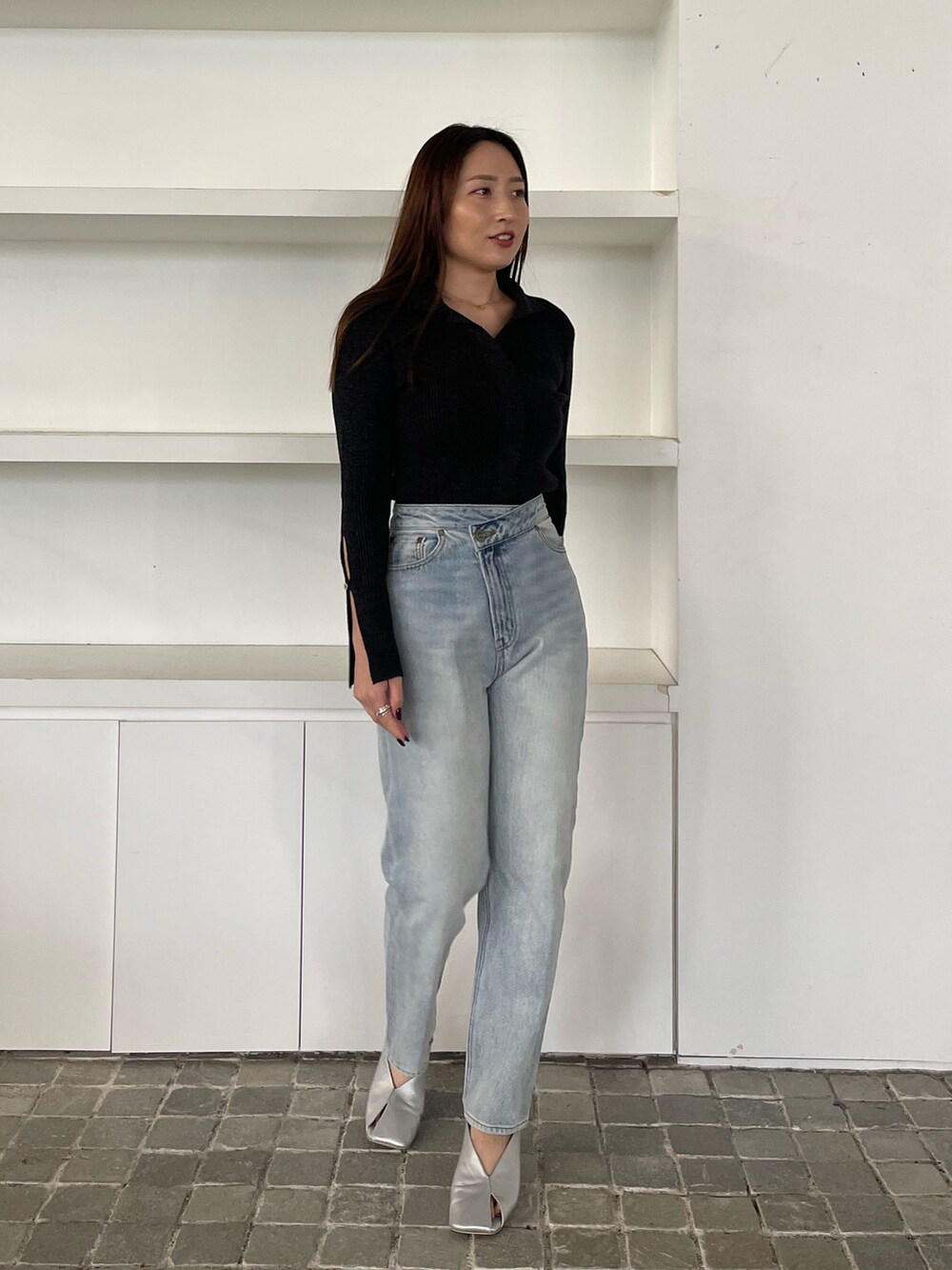 ブルー系のデニムパンツ、ブラック系のニット/セーターを着用したレディースの冬コーディネートの2枚目の写真