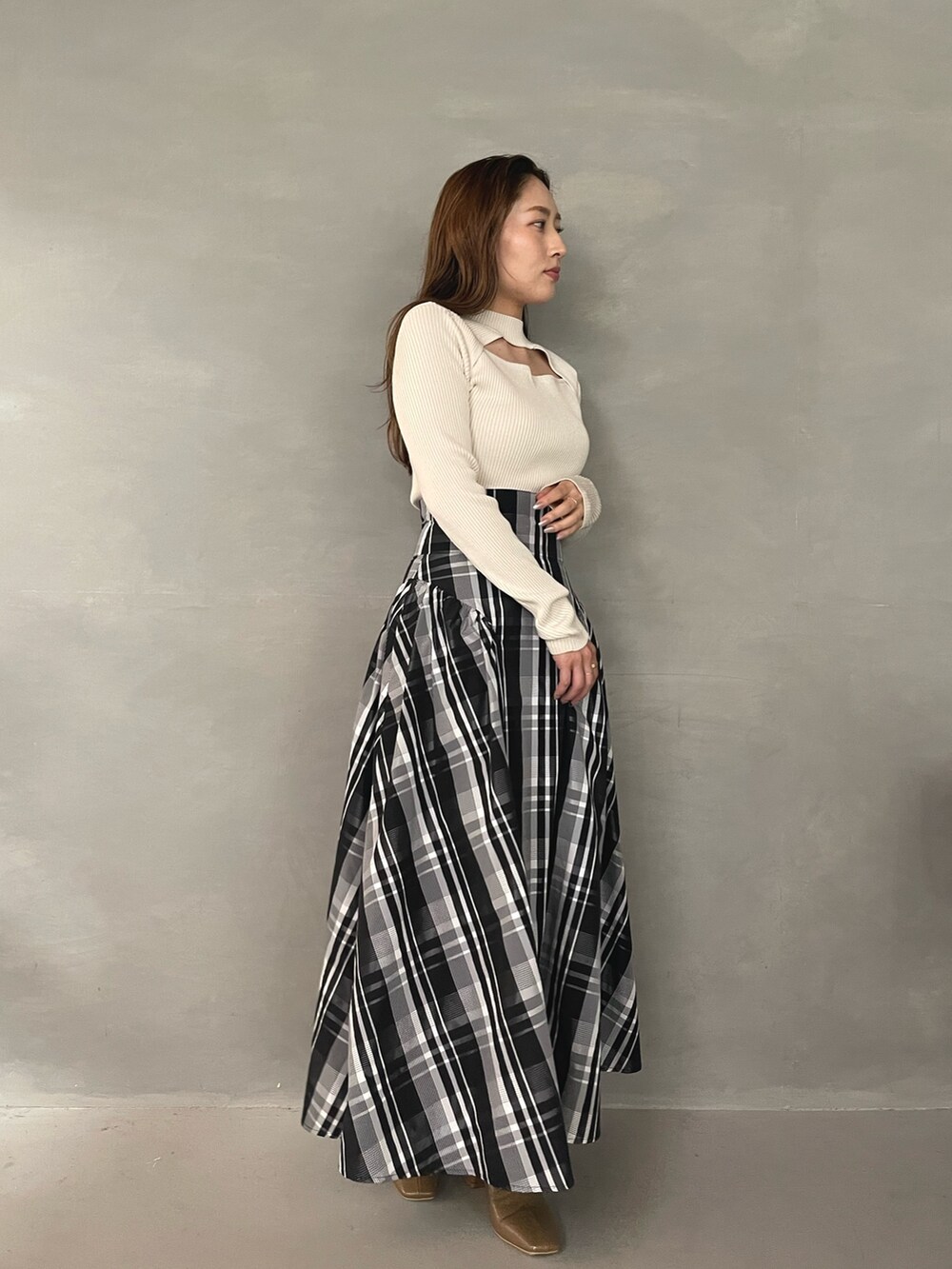 ベージュ系のブーツ、ホワイト系のニット/セーター、ホワイト系のスカートを着用したレディースの秋コーディネートの4枚目の写真