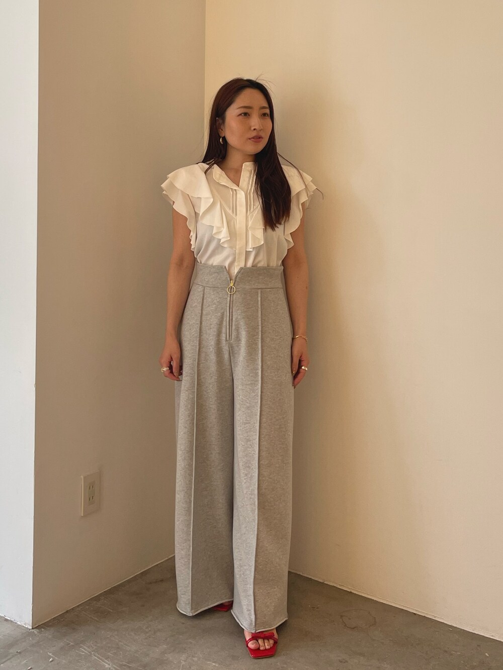 レッド系のサンダル、ホワイト系のシャツ/ブラウス、グレー系のスウェットパンツを着用したレディースの春コーディネートの3枚目の写真