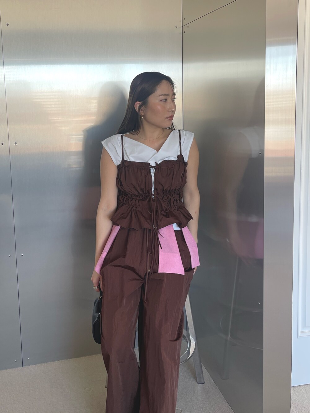 ブラック系のパンプス、ホワイト系のTシャツ/カットソー、ブラウン系のキャミソールを着用したレディースの春コーディネートの3枚目の写真