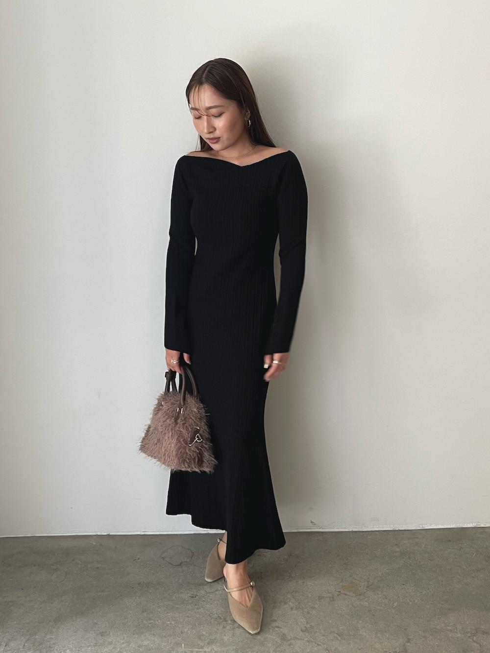 ブラック系のワンピース、ベージュ系のパンプス、ブラウン系のボストンバッグを着用したレディースの秋コーディネートの8枚目の写真