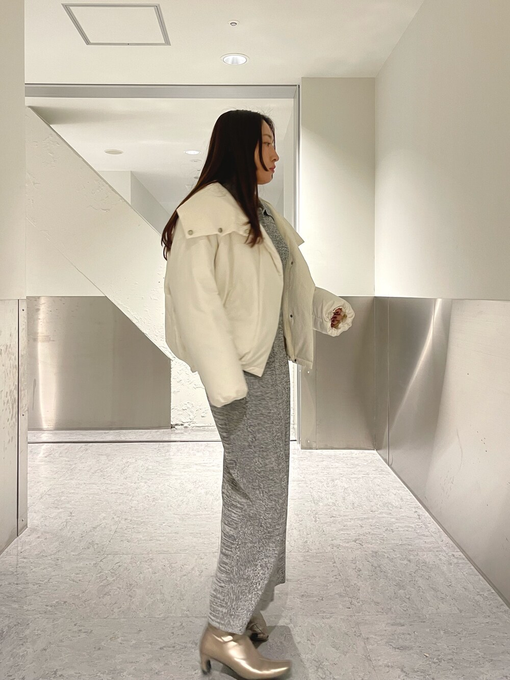 グレー系のワンピース、ホワイト系のダウンジャケット/コートを着用したレディースの冬コーディネートの2枚目の写真