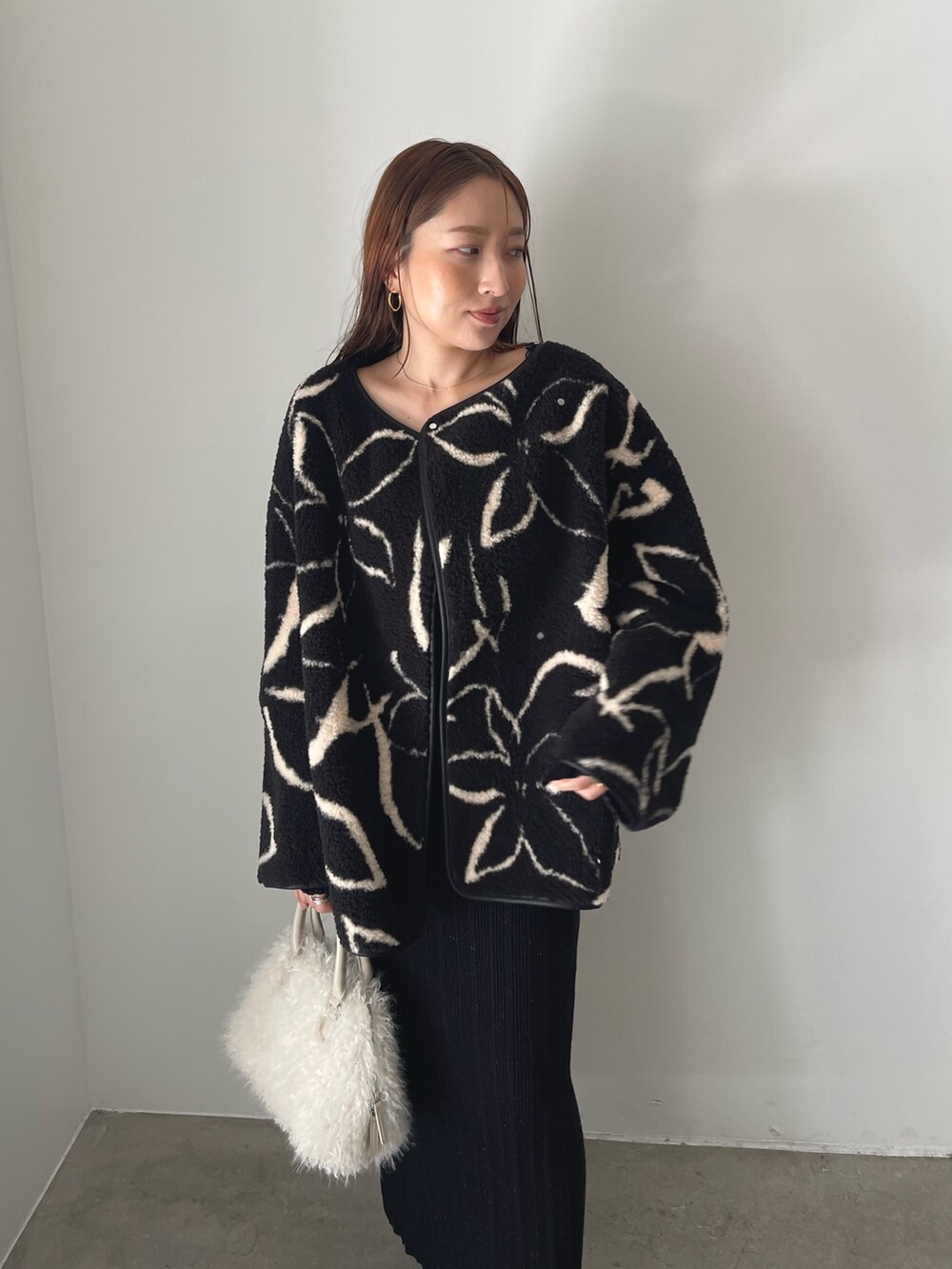 ブラック系のブーツ、ホワイト系のボストンバッグ、ブラック系のブルゾンを着用したレディースの秋コーディネートの7枚目の写真