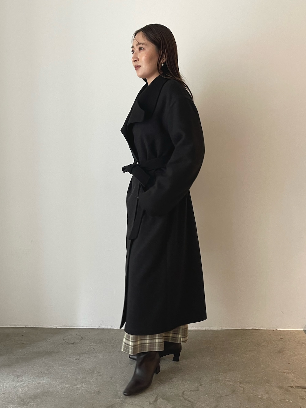 ブラウン系のスカート、イエロー系のハンドバッグ、グレー系のチェスターコートを着用したレディースの秋コーディネートの6枚目の写真